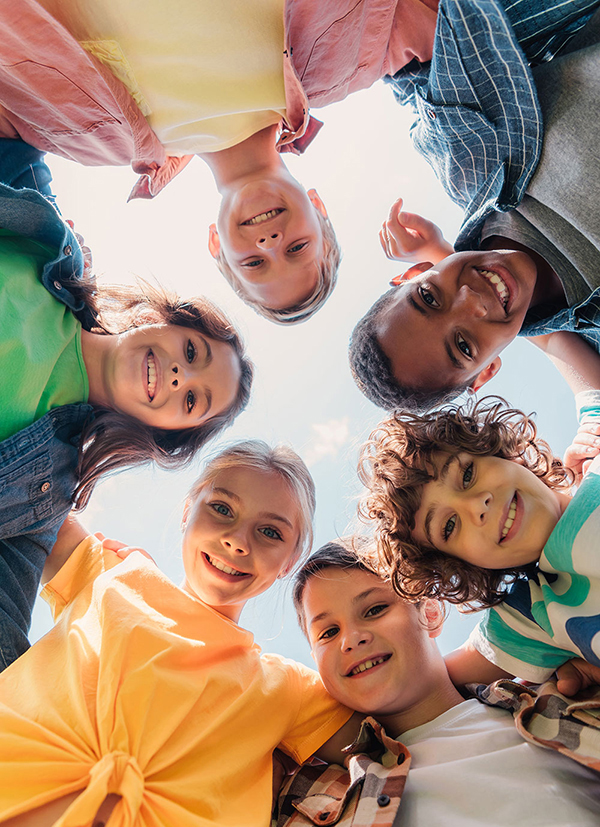 bottom view of cheerful multicultural kids looking at camera